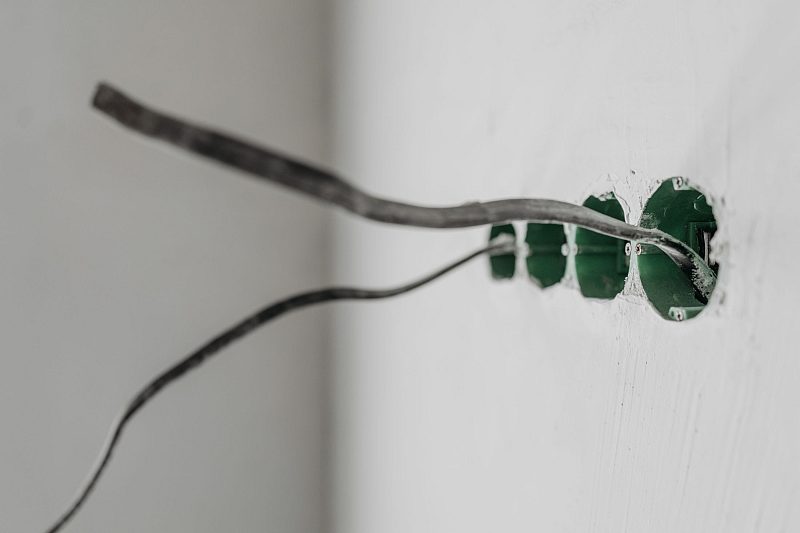 Damaged cable emerging from a wall during fault finding