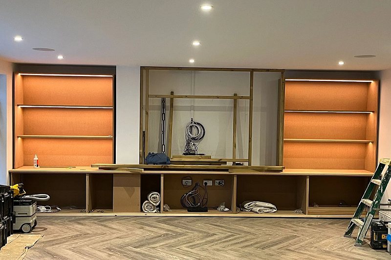 Media wall and alcove units at first fix, with cabling run in before the joinery is closed up