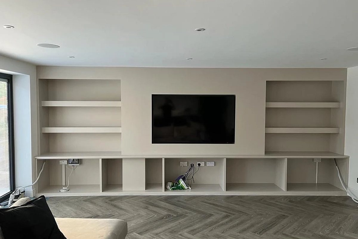 Completed media wall with television, shelving and recessed downlights above
