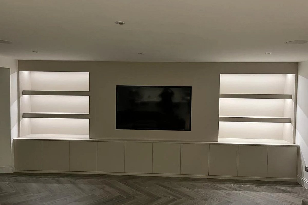 Alcove shelving lit by concealed LED strip lighting either side of the television