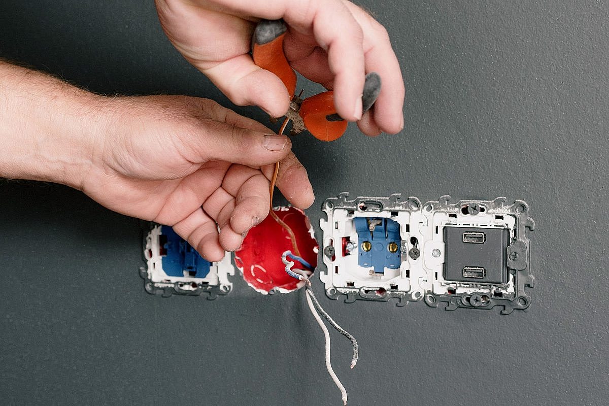Electrician fitting a new socket outlet on a domestic wall