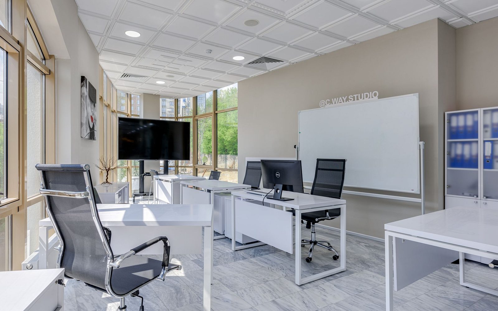 Open plan London office with white desks and suspended LED ceiling lighting