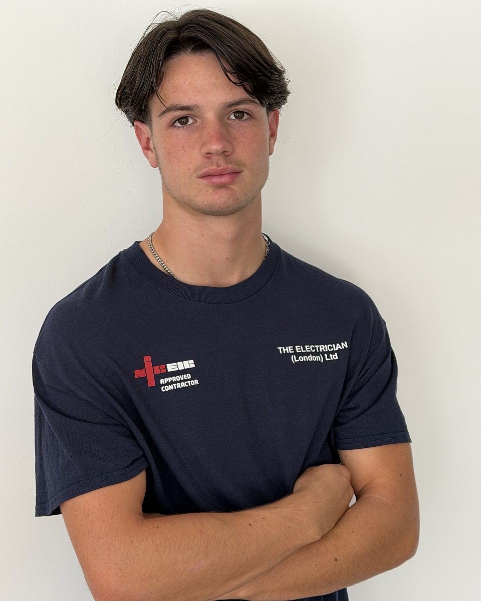 Taylor Boon, trainee electrician, in a company T-shirt with the NICEIC Approved Contractor logo
